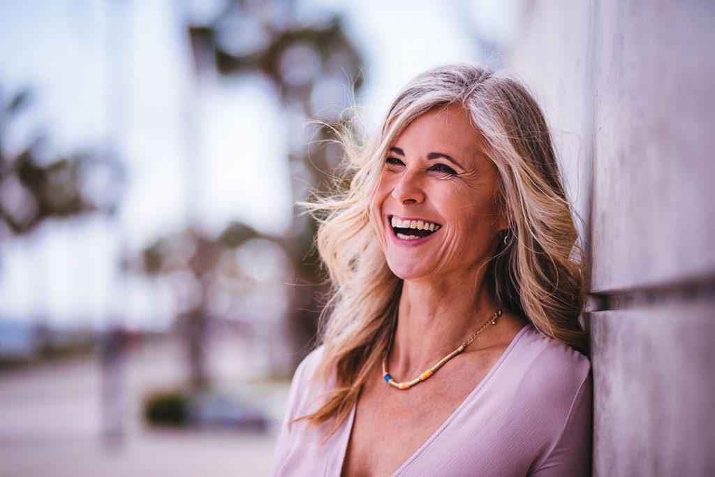 woman smiling leaning against wall 