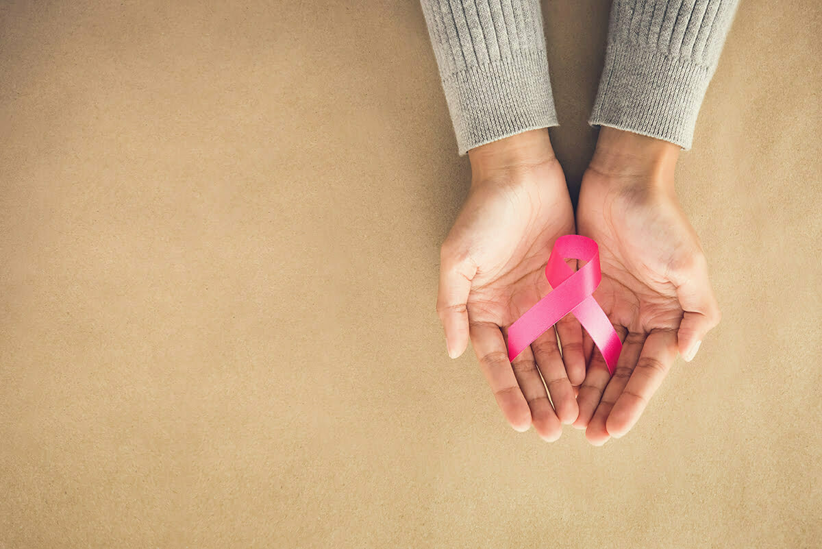 Woman holding breast cancer awareness ribbon.