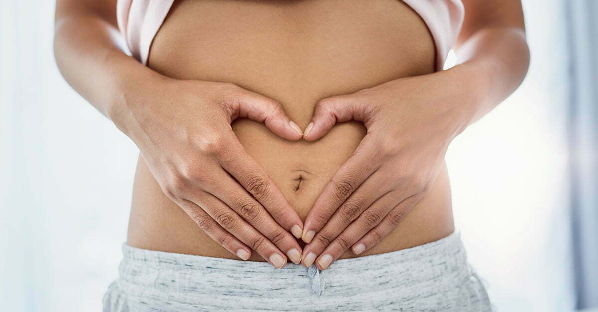 Woman making a heart over her tummy