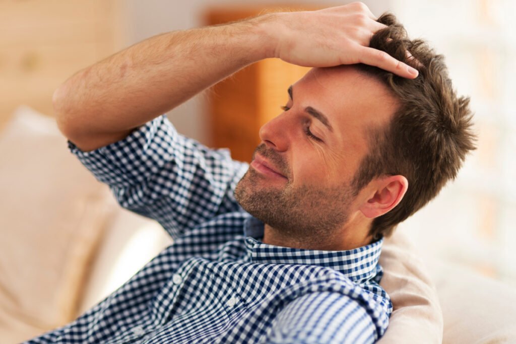 Man running hand through hair after Neograft hair transplant 