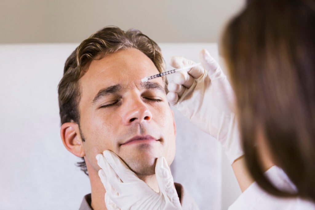 Male patient getting Botox injections to treat furrows between the brows