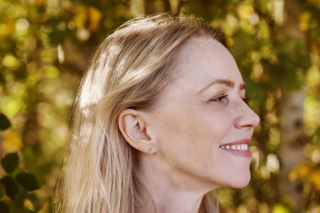 Close up of mature woman from the side with hair tucked behind ear