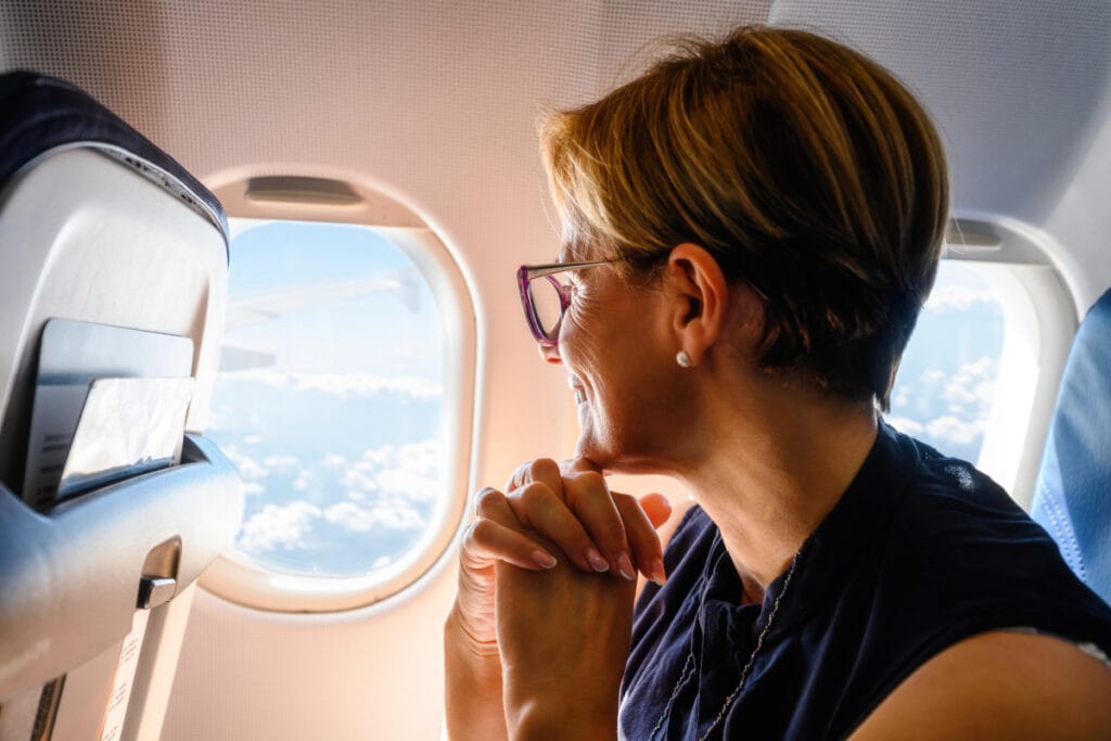 Mature woman looking out airplane window